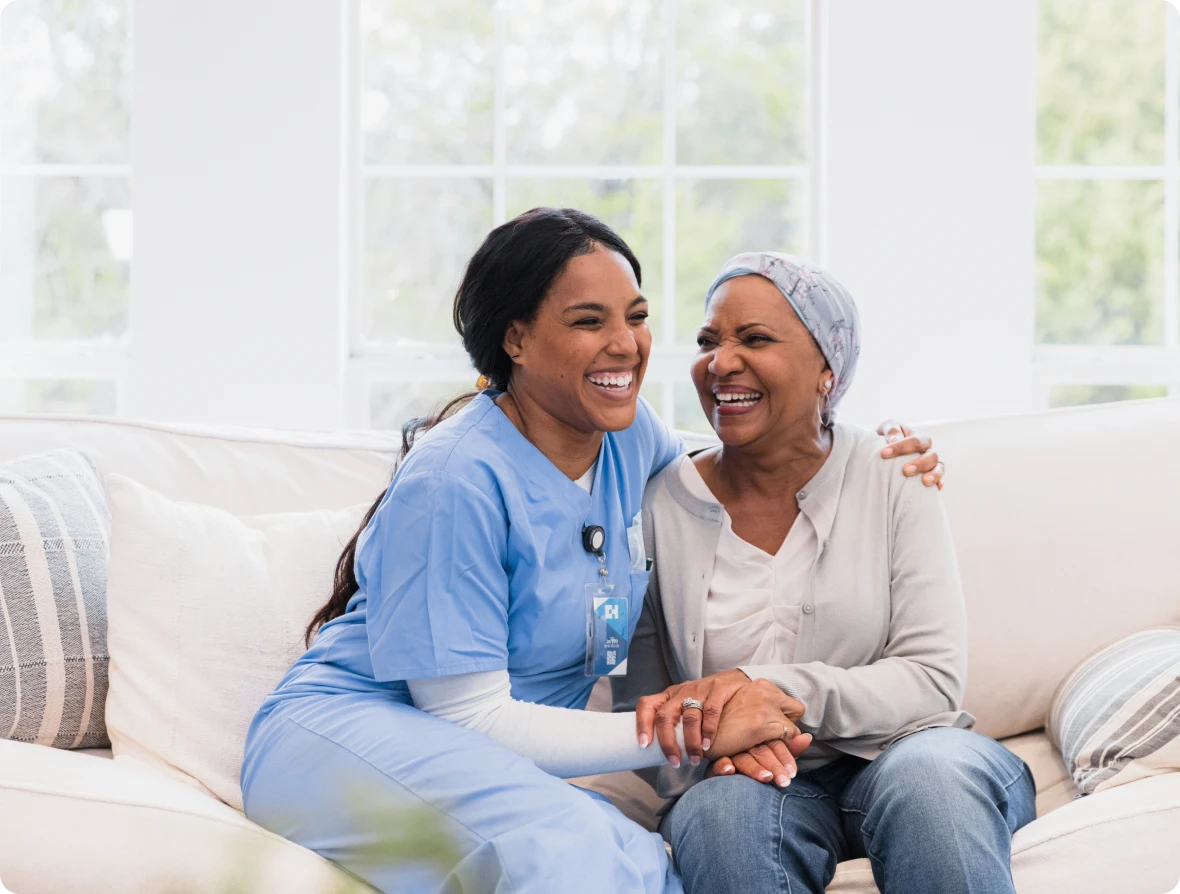 Nurse comforting and laughing with patient.