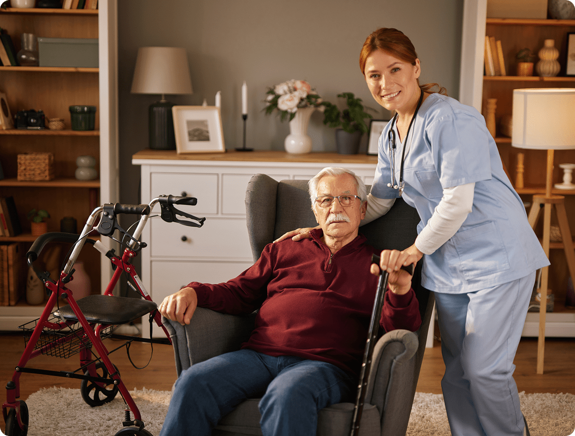 Elderly man with caregiver in living room.