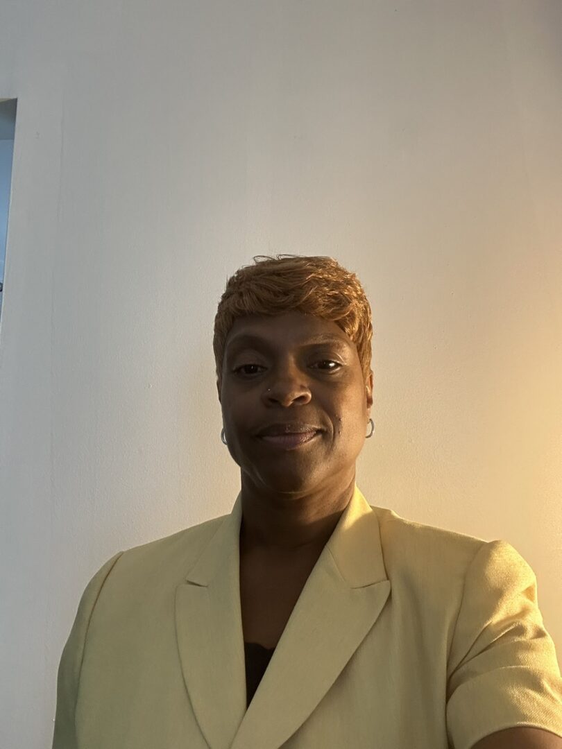 Person smiling in yellow blazer